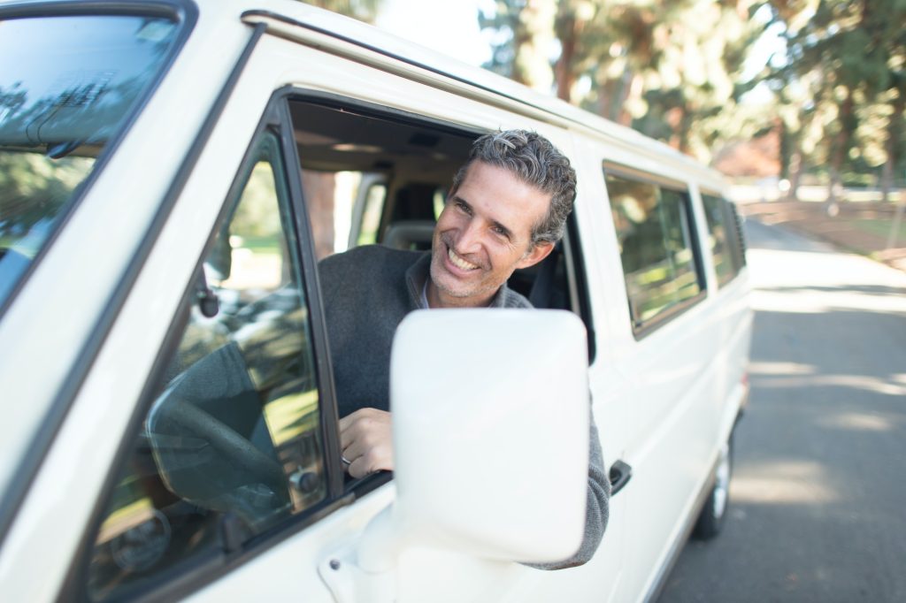 man in gray sweater leaning on van window