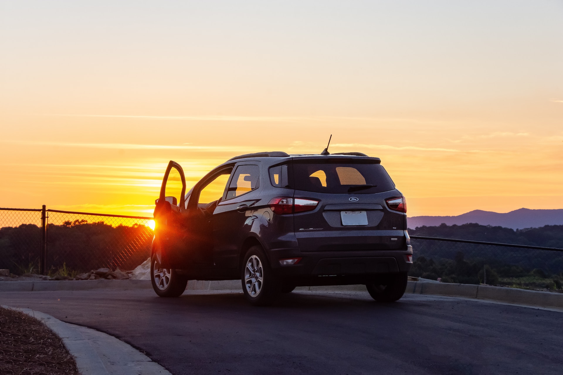 black chevrolet crew cab pickup truck on road during sunset